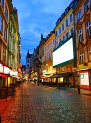 Empty Street in European City at Night with a Blank Billboard