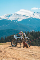 a motorcycle in the mountains with a dog next to it
