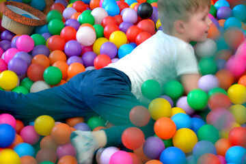 Child having fun in a colorful ball pit at the playground
