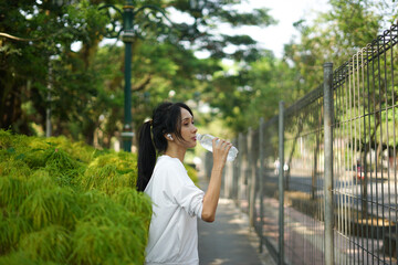 beautiful woman drinking water from bottle after exercise