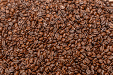 Close-up of coffee beans with a lot of them. The beans are brown and have a lot of detail. Background from coffee beans.