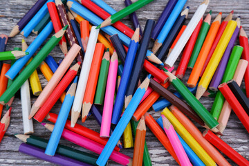 A bunch of old handwritten colored pencils on a white wooden background.The concept of replacing pencils, storage, sale of stationery. Products for creativity and school.
