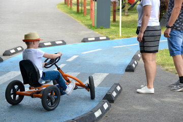 boy driving quad bike, four wheel cycle car, spring brightly morning, sunny day