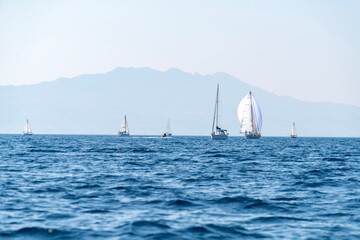 Sailing ship yachts with sails. Sailboat in the Sea over mountains background. Sailing boats...