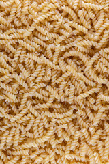 Pasta fusilli texture. Dry uncooked wholegrain italian pasta fusilli natural texture or background, close-up, high resolution.