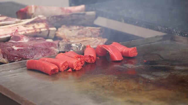 Chistorra y cortes de carne en la parrilla listos para cocinarse