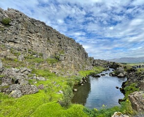Fototapeta premium A captivating image of a serene river flowing through the rugged terrain of Thingvellir National Park in Iceland. 