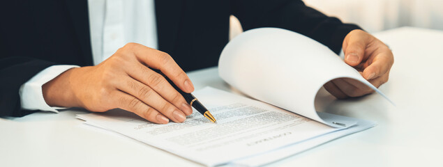 Business executive signing contract agreement document on the bale with the help from company...