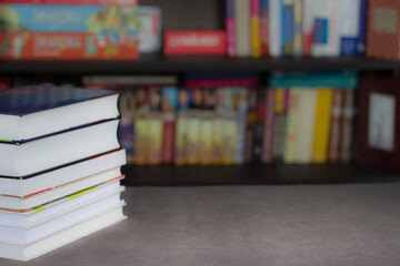 Obraz premium a stack of books on a library table with a bookcase in the background and a place for text, an object, or an insert