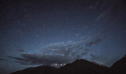 Night landscape in the Tien Shan mountains in Tajikistan in the Pamirs, stars and mountains with...