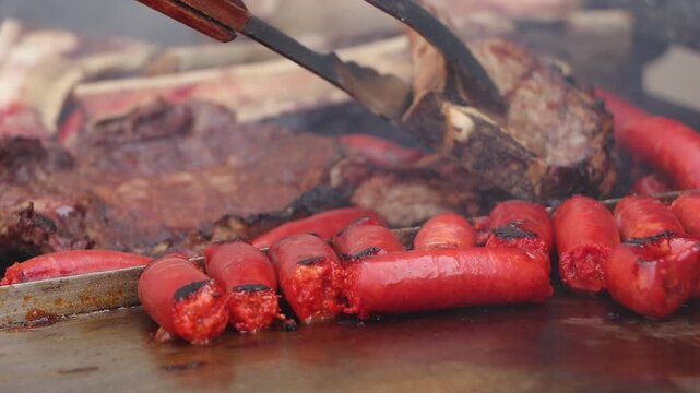 Cortes de carne y chistorra preparandose en la parrilla