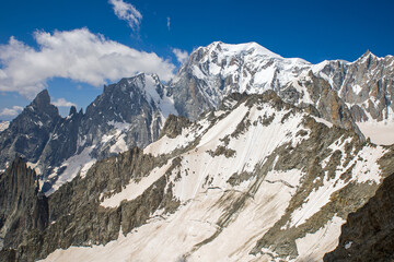 view of the mont blanc massif in the alps a snow slope covered with brown sahara dust and a rock avalanche in the background the white snow of mont blanc	
