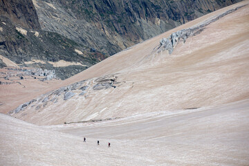 View of a glacier in the alps whose snow is covered with brown sahara sand 