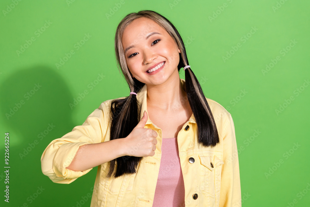 Sticker portrait of pretty young woman show thumb up wear jacket isolated on green color background