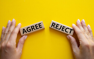 Agree or Reject symbol. Concept word Agree or Reject on wooden blocks. Businessman hand. Beautiful yellow background. Gender and Agree or Reject concept. Copy space