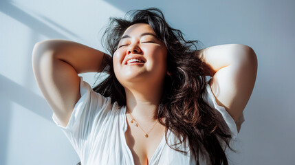 Naklejka premium plus size Asian woman holding the back of her head as she enjoys the warm sun after a yoga workout to improve wellness and tap into inner peace for mindfulness and healthy lifestyle 