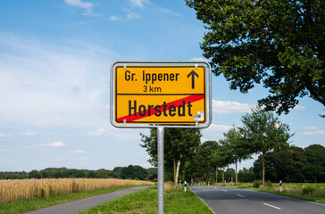 Horstedt, Lower Saxony, Germany, July 15, 2024 -  Yellow sign of the village with a natural background