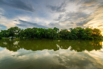 landscape lake views and the reservoir the forest summer water reflection with Twilight blue bright and orange yellow dramatic sunset sky in beach colorful nature background.
