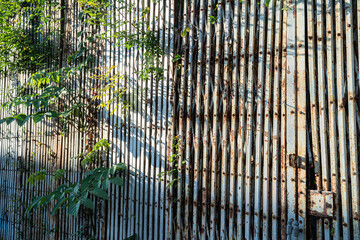 Old Wall sliding steel door,rusty iron hinged door tied with dense chains rusty old texture with...