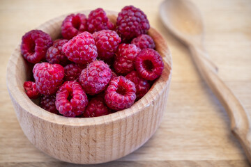 Sweet organic raspberry in wooden bowl