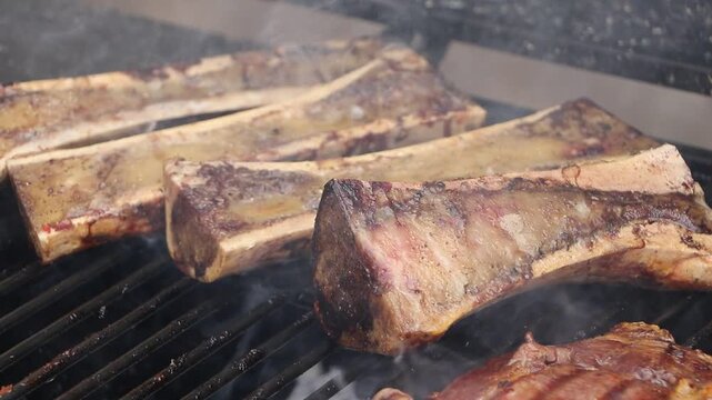 Tuetanos y corte de carne cocinados esperando sacarlos de la parrilla.mov