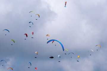 Sestola, Italy - 07 27 2024: Paraglider flies in the air. Aerial view of paragliding. Paraglider flies above the clouds in a bright sunny day. Concept of extreme sport.
