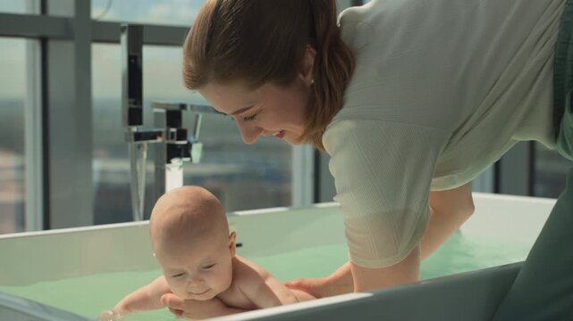 Baby explores water with support from adult, engaging in early sensory experiences. Scene promotes child's motor skills and comfort in water. Concept of early childhood development and sensory growth