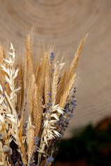 decorations with wheat and other plants in a vase and an embroidered ornament