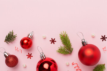 Red christmas balls with decor on color background, top view