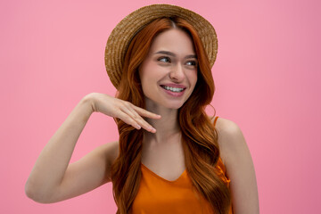 Cute long-haired young woman in orange top looking flirty