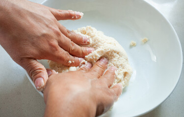woman kneading corn flour inside a bowl