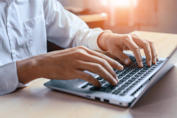 Businessman hand typing on computer keyboard of a laptop computer in office. Business and finance concept. uds
