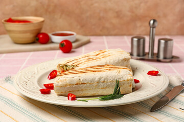 Plate with tasty shawarma and chilli on pink tile table