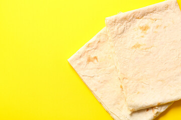 Fresh thin lavash on yellow background