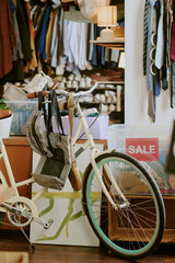 Bicycles, a backpack, and shelves full of clothing and accessories seen in cozy thrift store...