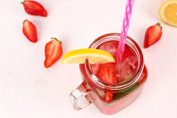 Mason jar of tasty strawberry drink on white background