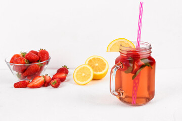 Mason jar of tasty strawberry drink on white background