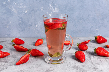 Glass of tasty strawberry juice on grey table