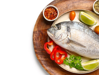 Plates with raw dorado fish and ingredients on white background