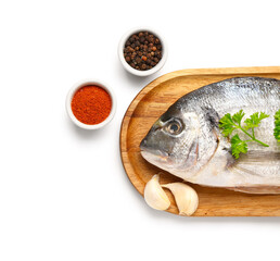 Wooden board of raw dorado fish with spices on white background