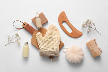 Beautiful composition with wooden guasha body massage tool, mitten and bath supplies on white background