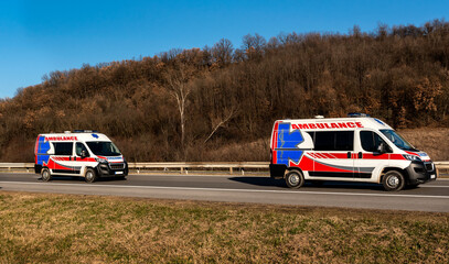 Two ambulance vans speeding on a highway at sunset. Ambulance cars responding to the scene of an emergency. © Ivan