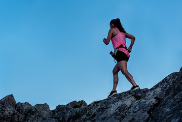 Woman silhouette running outdoors. Healthy lifestyle concept, people go in sports. Woman running on a cliff in the mountains, sense of balance and calmness.