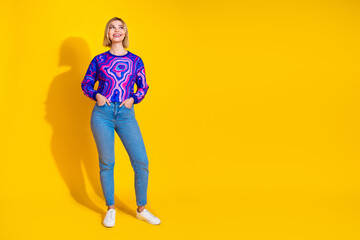 Fototapeta premium Full size photo of pretty young girl look up empty space posing wear trendy colorful blue outfit isolated on yellow color background
