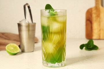Glass of tasty lemonade and mint on white background