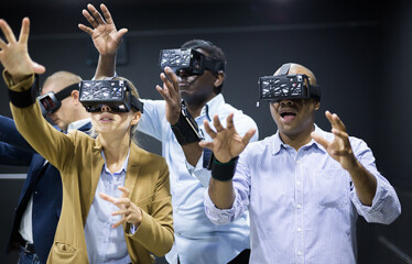 Colleagues playing video games using virtual reality glasses during team building