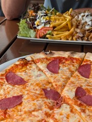 Delicious Pizza and Turkish Doner Kebab with Fries and Salad on Wooden Table Top View