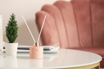 Aroma diffuser and houseplant on table in living room