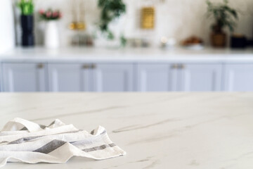 A kitchen countertop with a striped kitchen towel and modern cabinetry in a bright, airy space