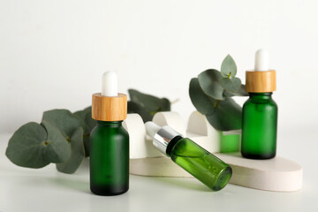 Beautiful composition with bottles of eucalyptus essential oil and plaster stands on white background, closeup